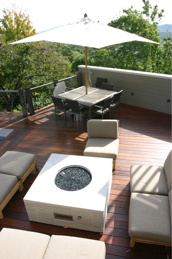 Example of a large minimalist backyard deck design in San Francisco with a fire pit and no cover