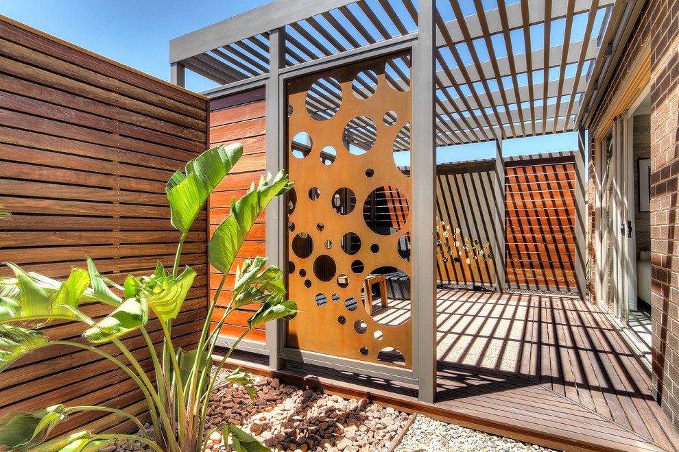 Inspiration for a contemporary side yard deck remodel in Adelaide with a pergola