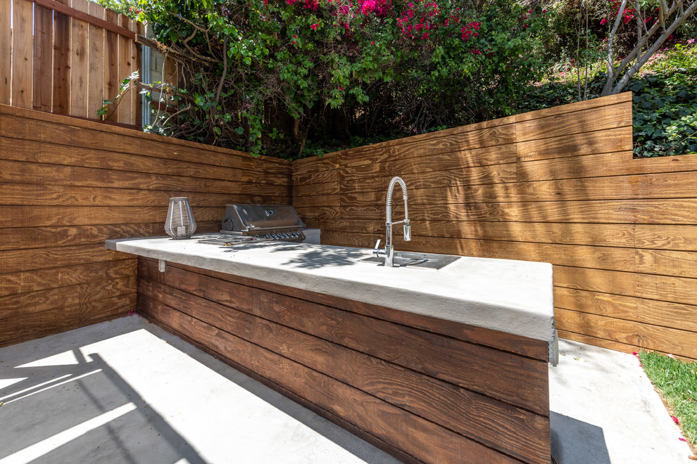 Outdoor kitchen deck - large contemporary backyard outdoor kitchen deck idea in Los Angeles with a pergola