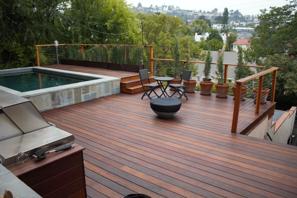 Inspiration for a mid-sized modern backyard outdoor kitchen deck remodel in Los Angeles with a pergola