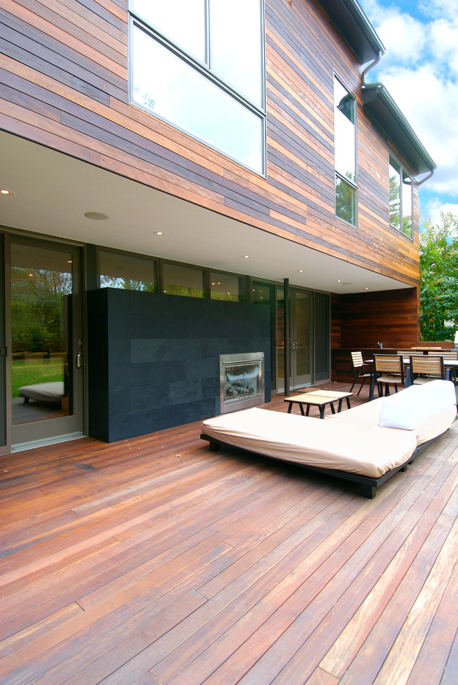 Inspiration pour une terrasse arrière design de taille moyenne avec un foyer extérieur et aucune couverture.