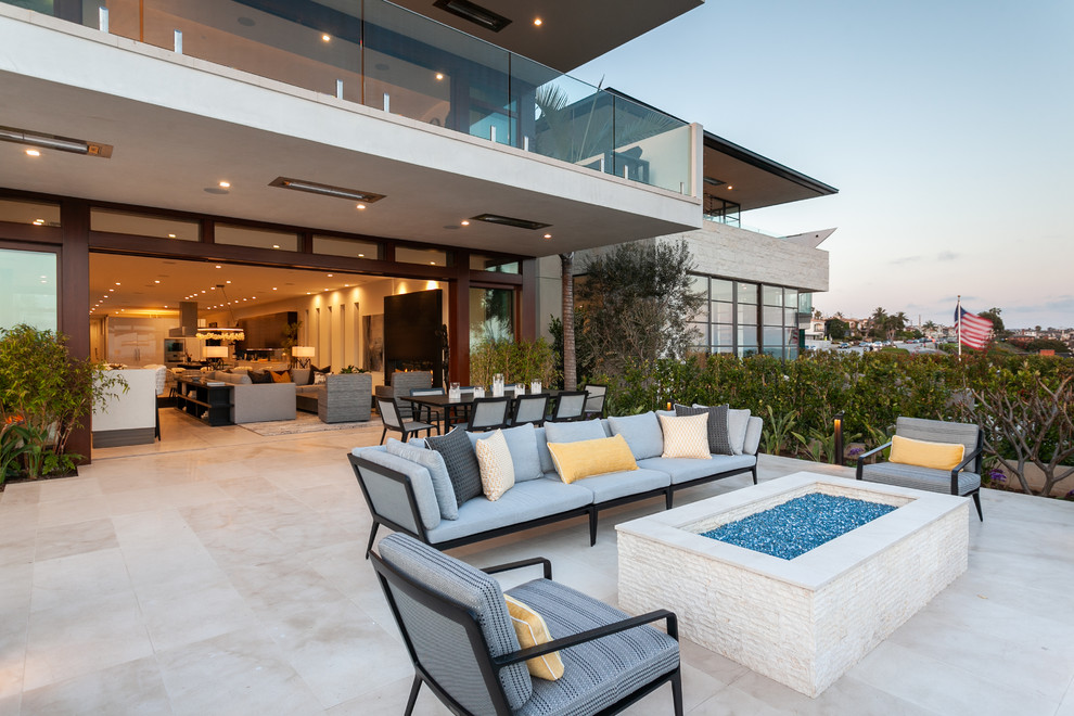 Inspiration pour une grande terrasse latérale design avec un foyer extérieur et une extension de toiture.
