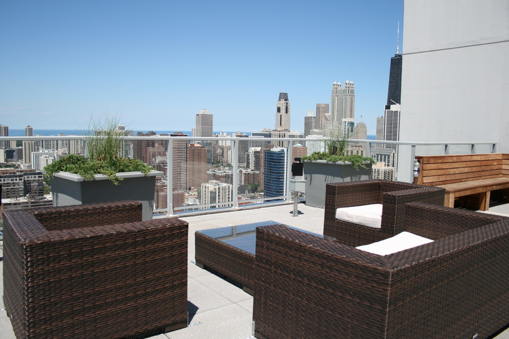 Example of a small trendy rooftop deck design in Chicago with a fire pit and a roof extension