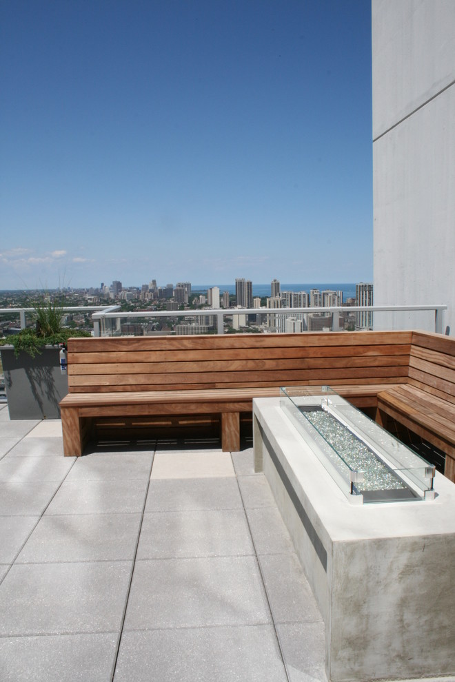 Example of a small trendy rooftop deck design in Chicago with a fire pit and a roof extension