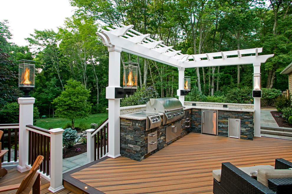 Cette photo montre une grande terrasse arrière montagne avec une cuisine d'été et une pergola.