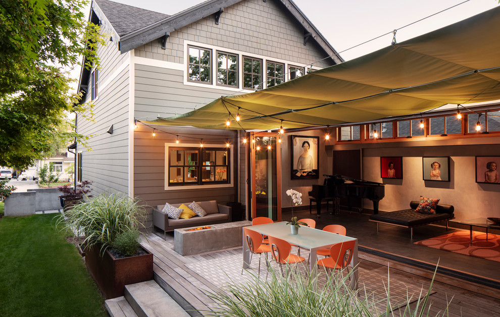Inspiration pour une terrasse latérale design de taille moyenne avec un foyer extérieur et un auvent.