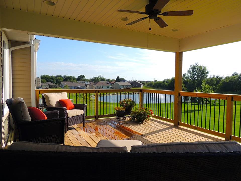 Example of a mid-sized classic backyard deck design in Cedar Rapids with a roof extension