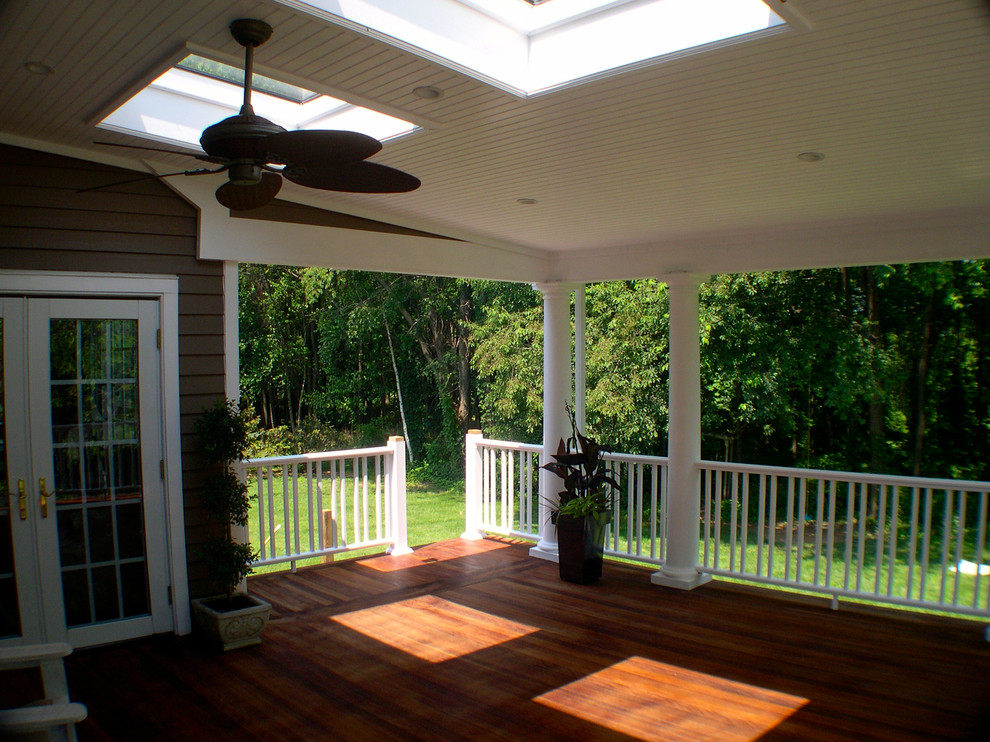 Example of a mid-sized classic backyard deck design in Philadelphia with a roof extension