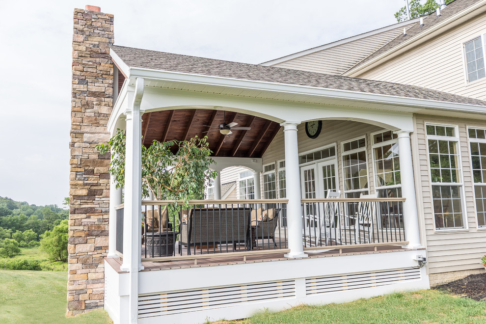 Example of a large transitional backyard deck skirting design in Baltimore with a roof extension