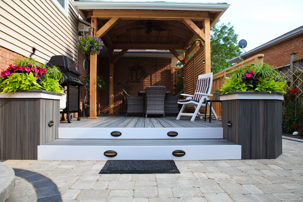 Inspiration for a small coastal side yard deck remodel in Toronto with a roof extension