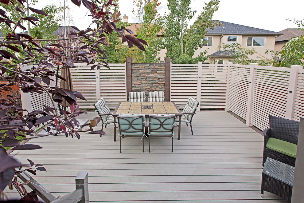 Inspiration for a large transitional backyard deck remodel in Calgary with no cover