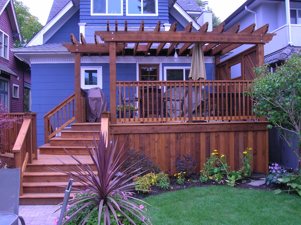 Deck - large traditional backyard deck idea in Vancouver with a pergola