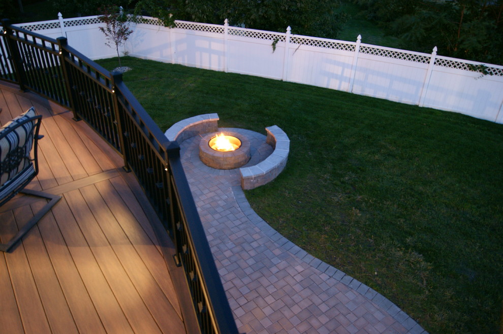 Example of a mid-sized trendy backyard deck design in New York with a fire pit and no cover