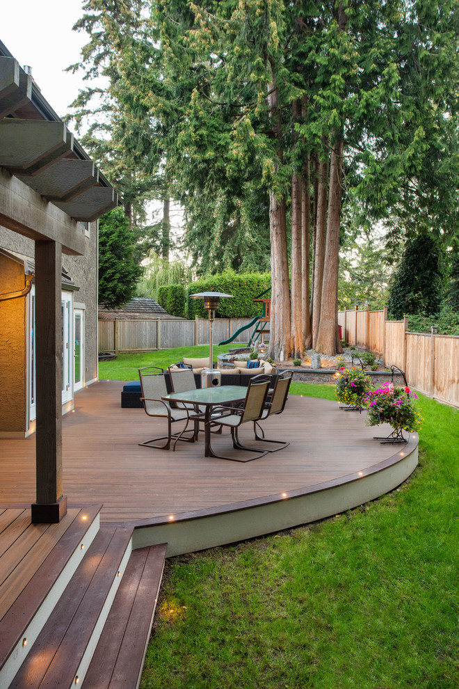 Huge minimalist backyard deck photo in Vancouver with a pergola