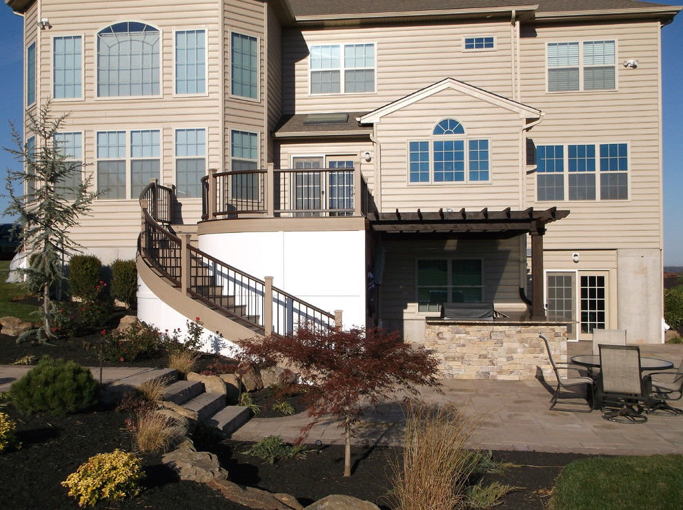 Curved Trex Decking with Paver Stone Patio and Outdoor Kitchen
