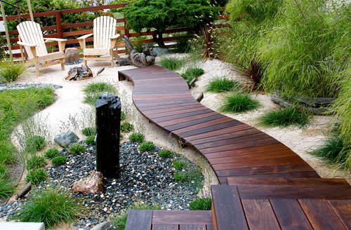 a curved and elevated decking path design in a beautifully landscaped garden