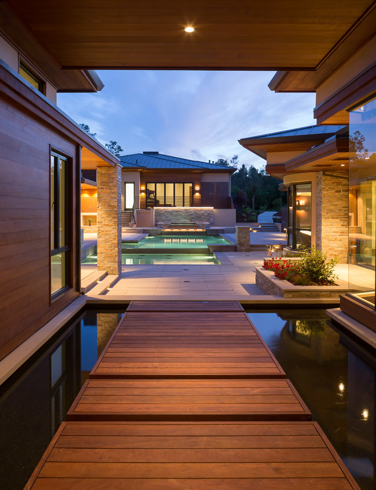 Large trendy backyard water fountain deck photo in San Francisco with a roof extension