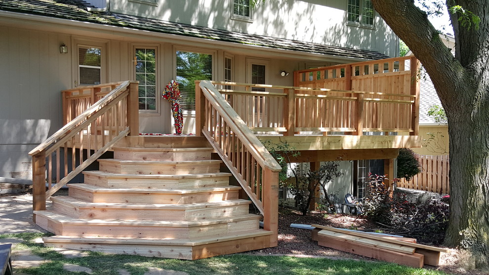 Example of a mid-sized classic backyard deck design in Omaha with no cover