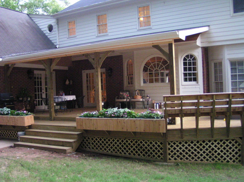 Photo of a large rustic back terrace in Atlanta with a potted garden and a roof extension.
