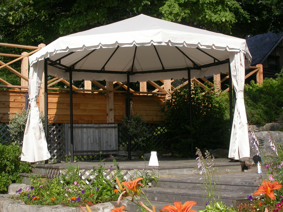 Immagine di una grande terrazza stile rurale dietro casa con un pontile e un parasole