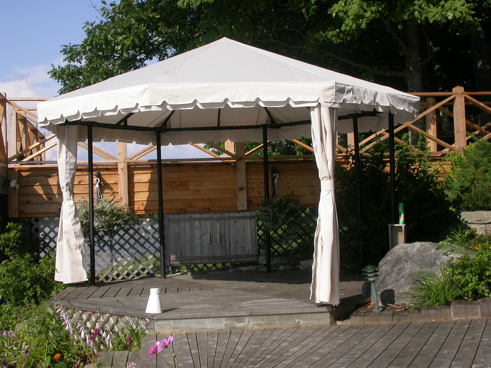 Immagine di una grande terrazza stile rurale dietro casa con un pontile e un parasole