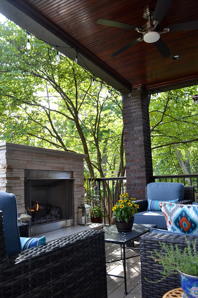Inspiration for a mid-sized transitional backyard deck remodel in St Louis with a fireplace and a roof extension