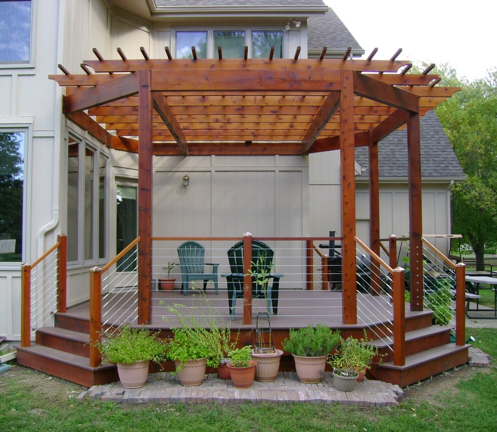 Example of a mid-sized transitional backyard deck design in Kansas City with a pergola