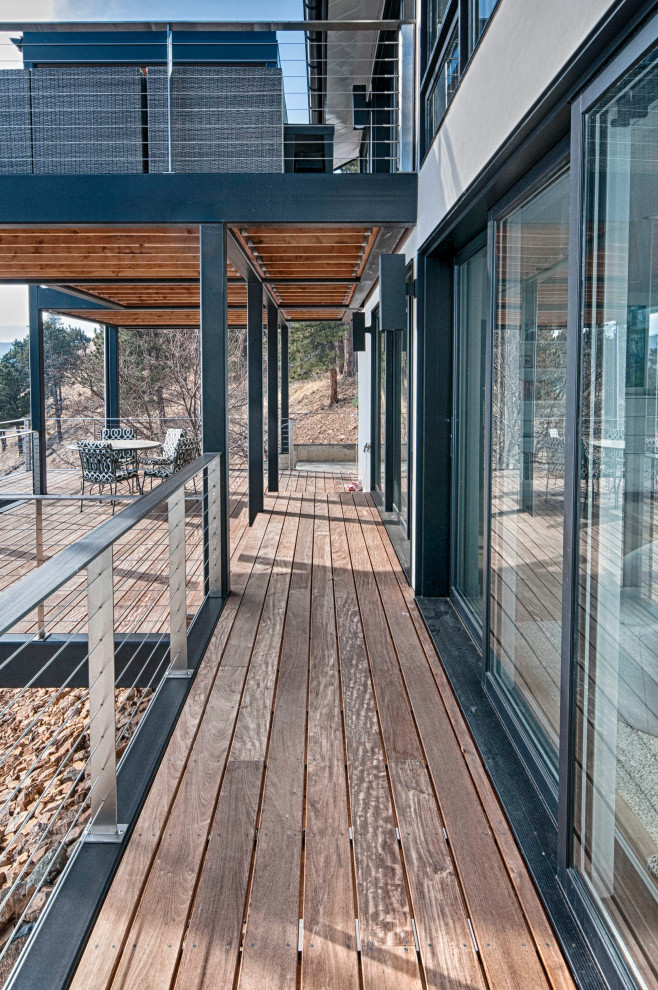 Foto di un'ampia terrazza design dietro casa e al primo piano con una pergola e parapetto in metallo