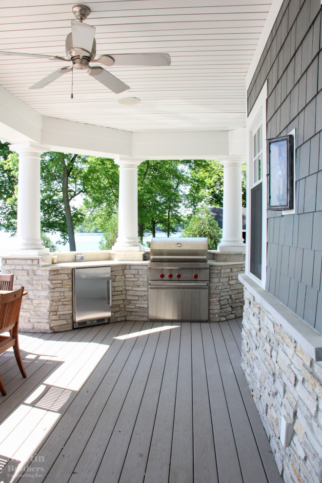 This is an example of an expansive nautical back terrace in Grand Rapids with an outdoor kitchen and a roof extension.