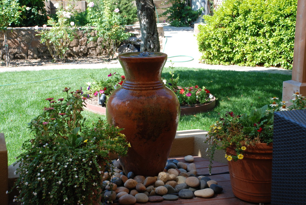 Modelo de jardín mediterráneo grande en patio trasero con fuente