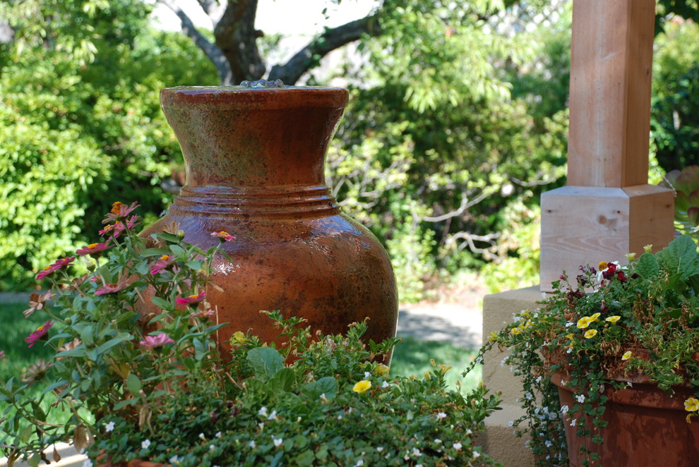 Esempio di una grande terrazza mediterranea dietro casa con fontane e una pergola