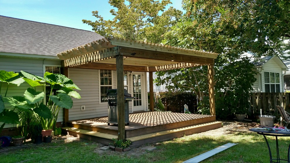 На фото: пергола на террасе среднего размера на заднем дворе в классическом стиле с летней кухней
