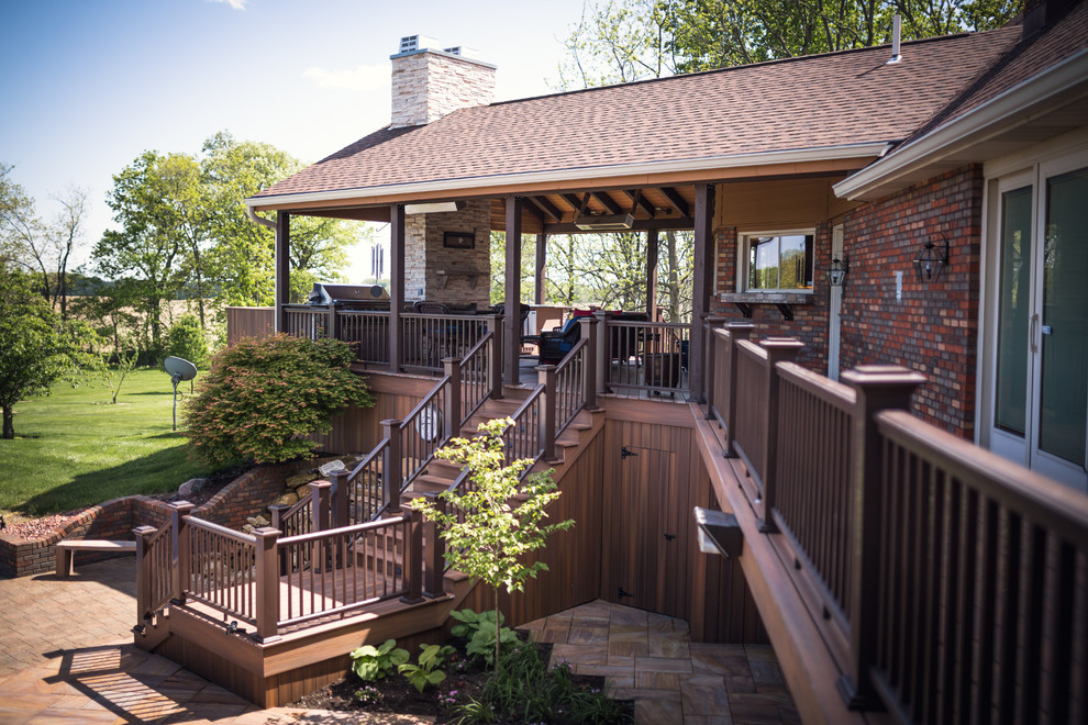 Réalisation d'une très grande terrasse arrière chalet avec une cuisine d'été et une extension de toiture.