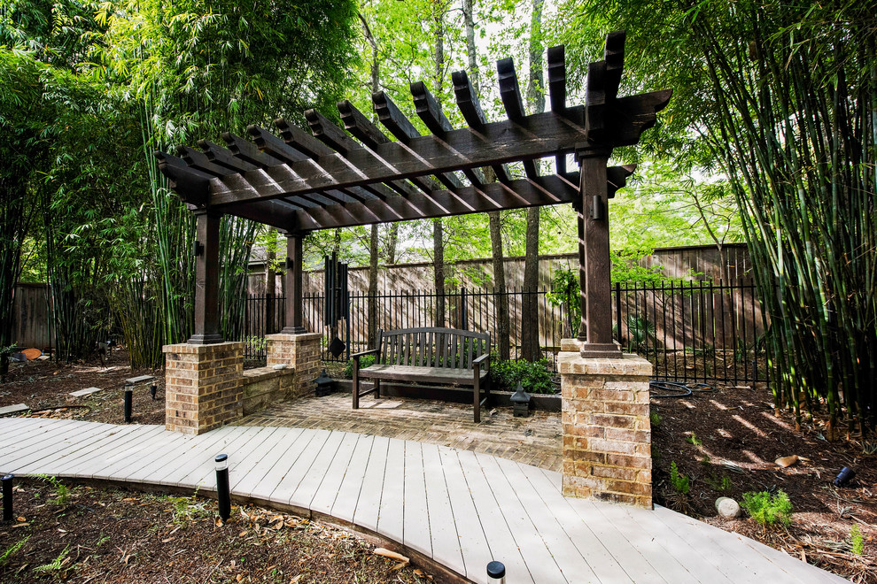 This is an example of a large contemporary back terrace in Houston with a pergola.