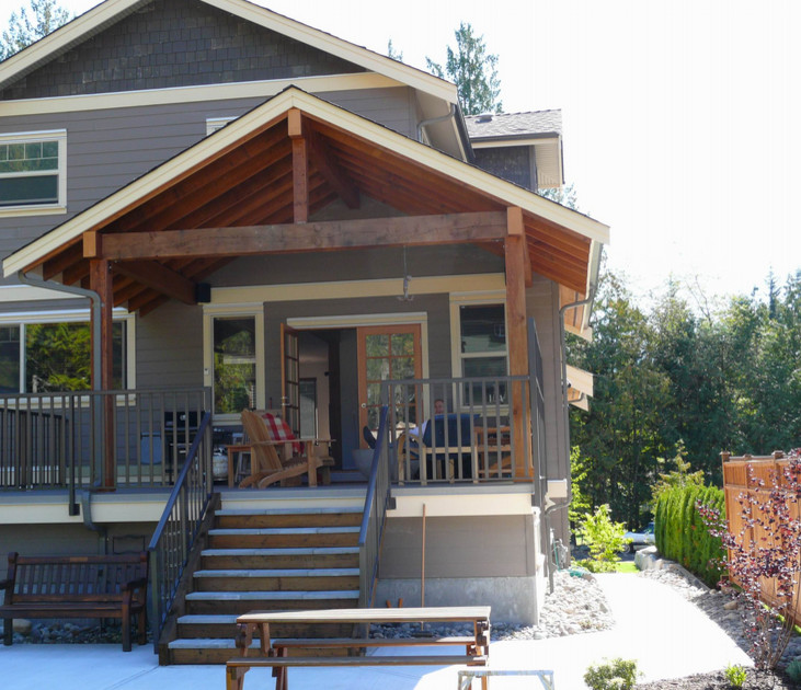 Large arts and crafts backyard deck photo in Vancouver with a roof extension