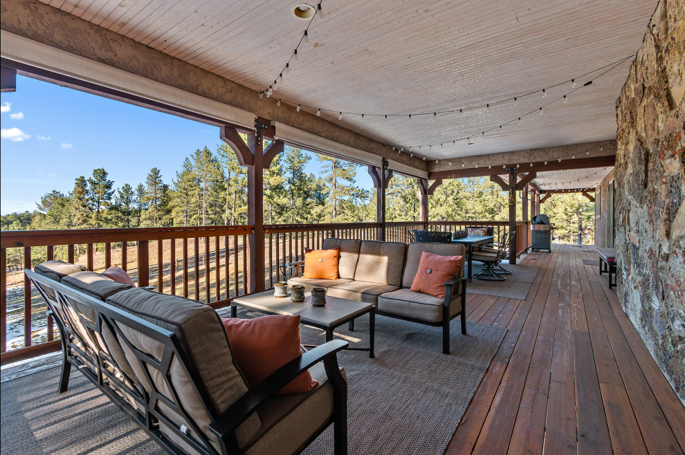 Example of a mid-sized trendy backyard deck design in Denver with a roof extension