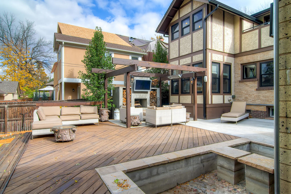 Idées déco pour une grande terrasse arrière montagne avec un foyer extérieur et une pergola.