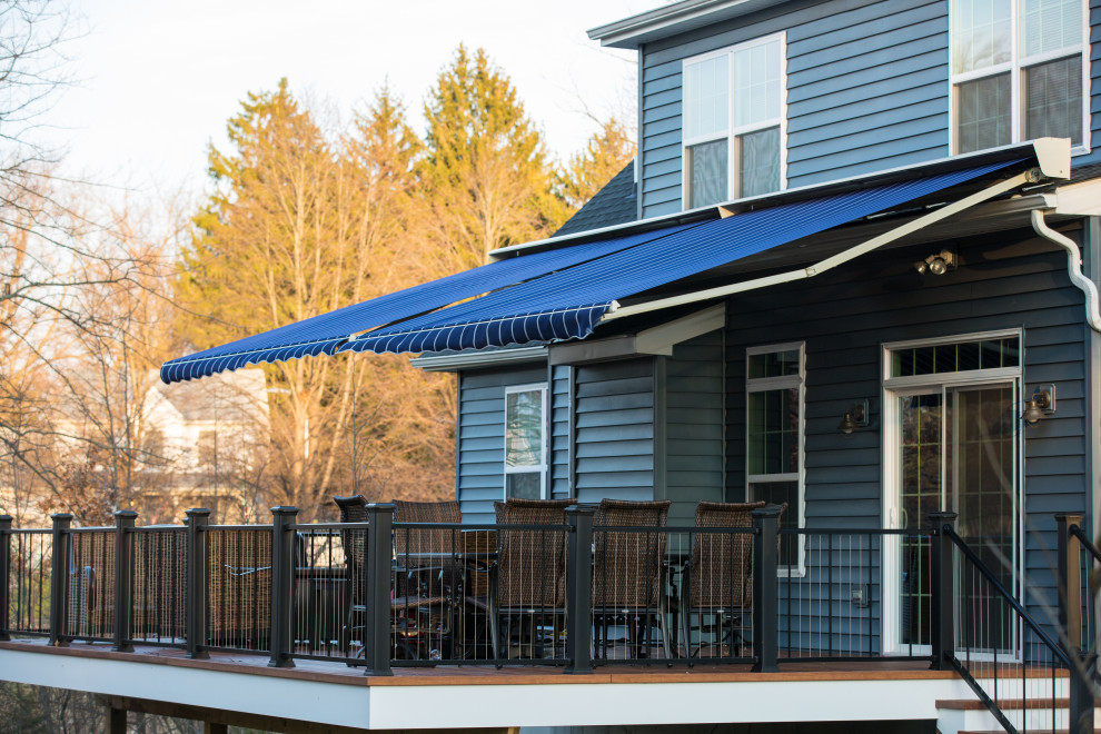 Immagine di una grande terrazza stile americano dietro casa con un focolare e un parasole