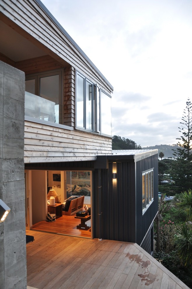 Idee per una terrazza design di medie dimensioni e dietro casa con un focolare e un tetto a sbalzo