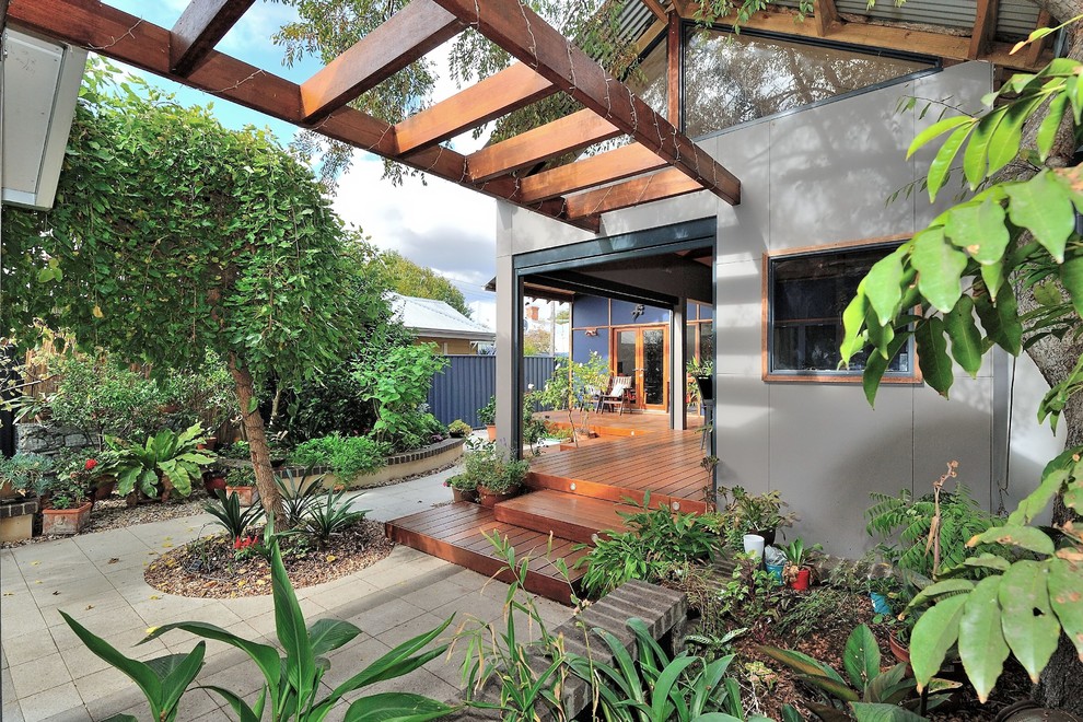 Cette photo montre une grande terrasse arrière tendance avec une cuisine d'été et une extension de toiture.