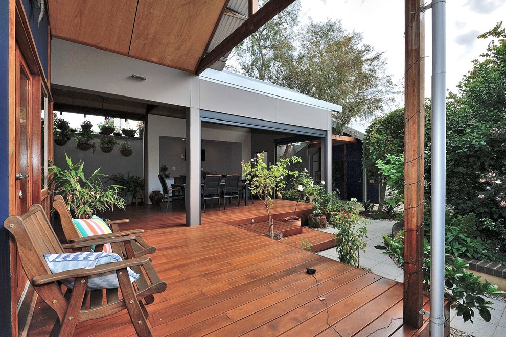 Источник вдохновения для домашнего уюта: большая терраса на заднем дворе в современном стиле с растениями в контейнерах и навесом
