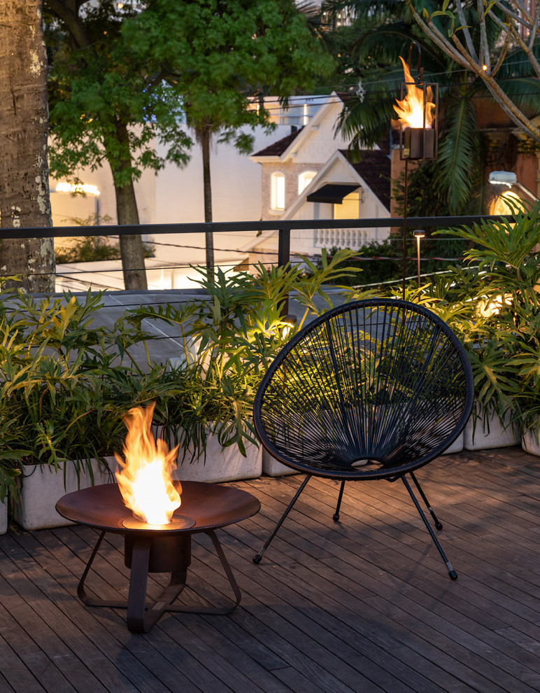 This is an example of an expansive urban roof rooftop terrace with a fireplace and no cover.