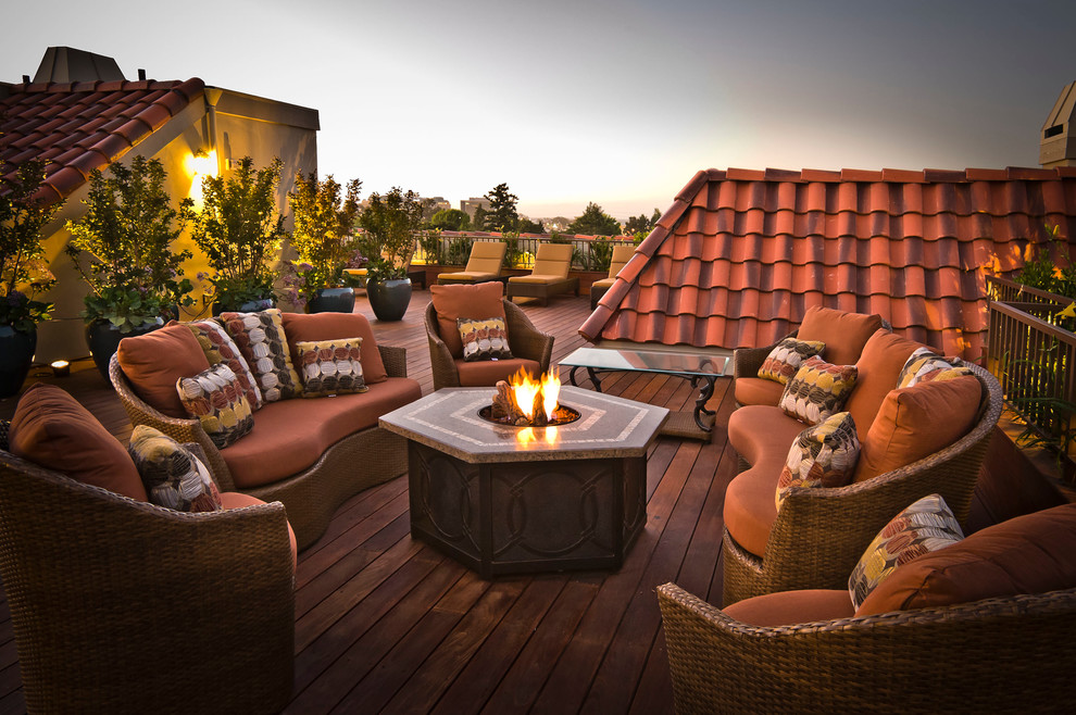 Esempio di una terrazza mediterranea con un focolare e con illuminazione