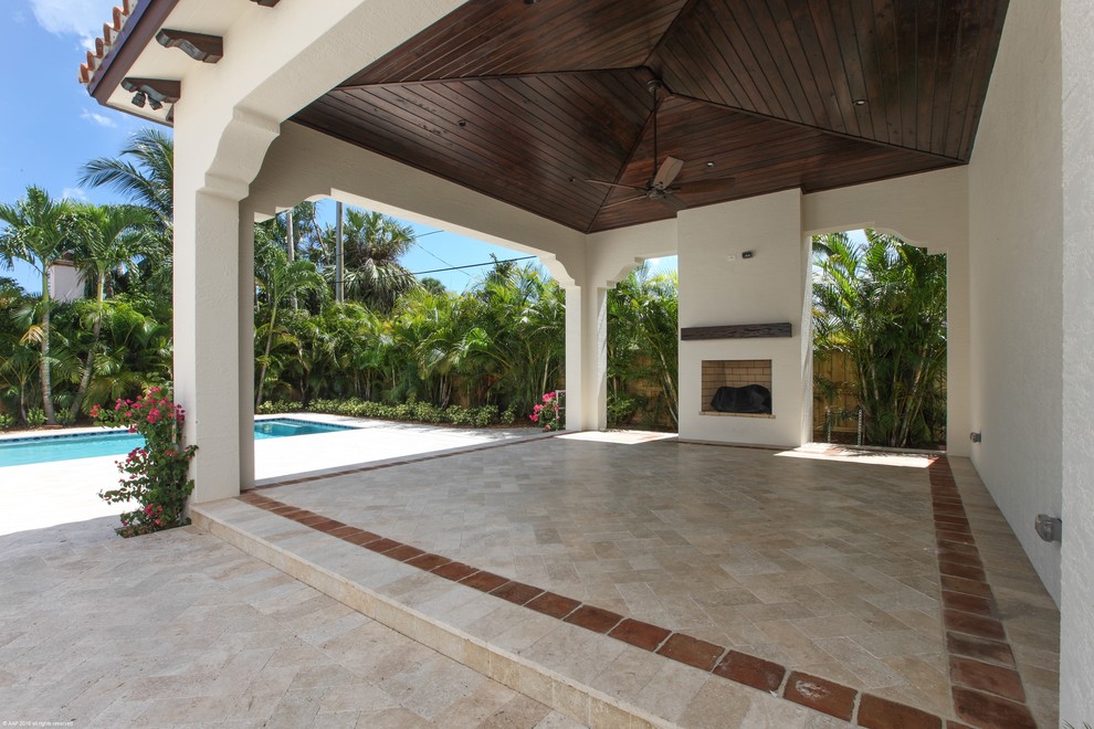 Inspiration for a large mediterranean back terrace in Miami with a fire feature and a pergola.