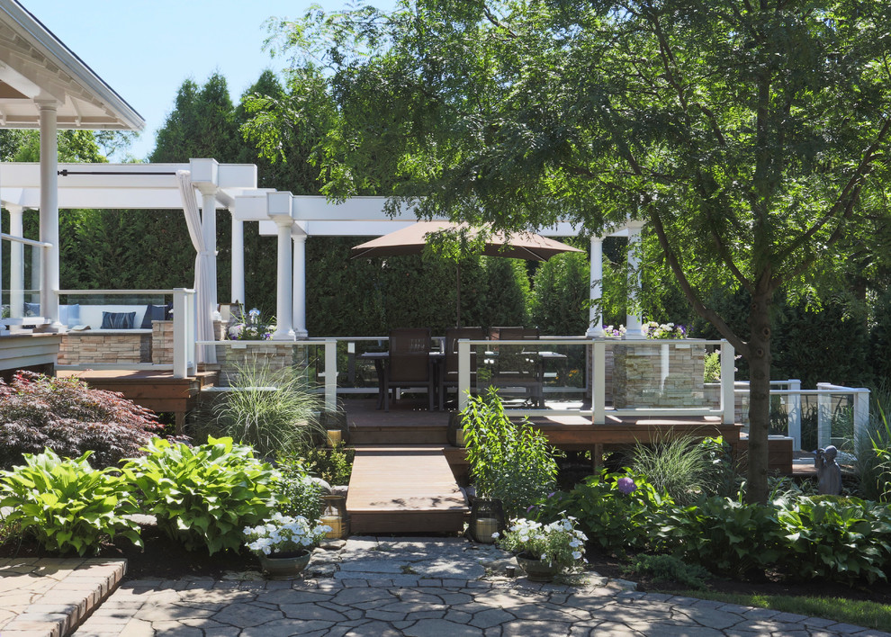 Photo of an expansive traditional back terrace in Chicago with an outdoor kitchen and a pergola.
