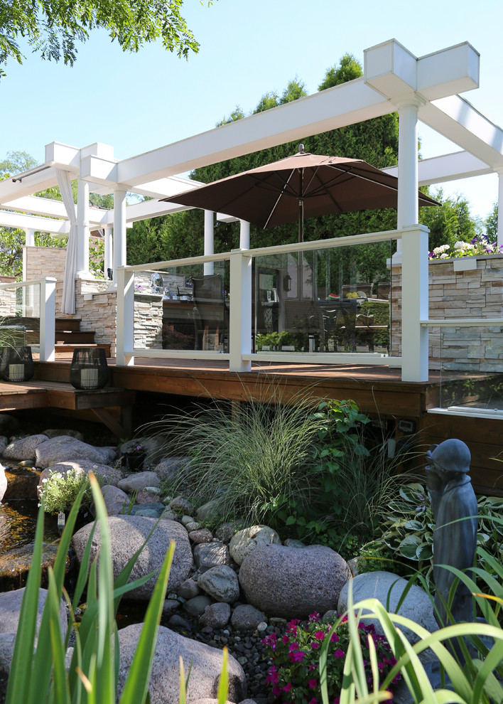 Inspiration for a huge transitional backyard outdoor kitchen deck remodel in Chicago with a pergola