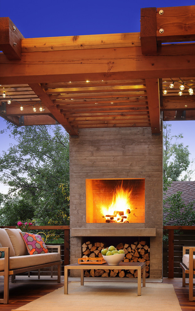 Inspiration for a modern backyard deck remodel in Denver with a fire pit and a pergola