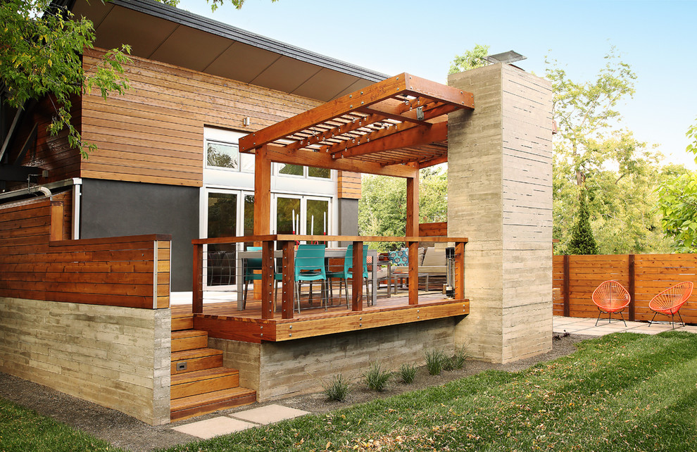 Idéer för en modern terrass på baksidan av huset, med en öppen spis och en pergola