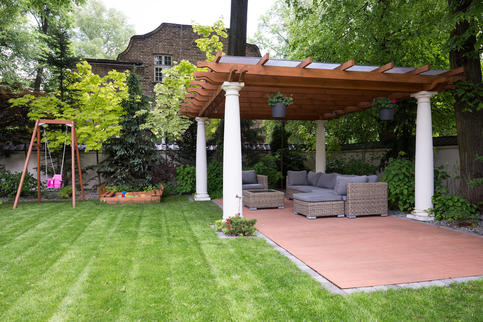 Diseño de terraza clásica renovada en patio trasero con pérgola