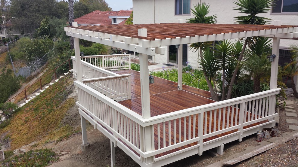 Mid-sized beach style backyard deck photo in Orange County with a pergola